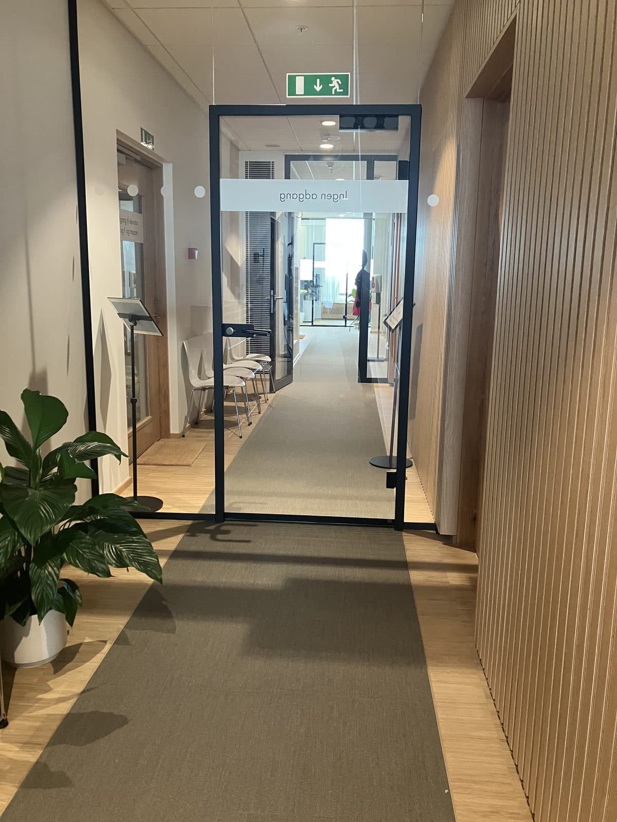 Indgangsområde med trævæg og planter hos Privat Psykiatrisk Center Aarhus