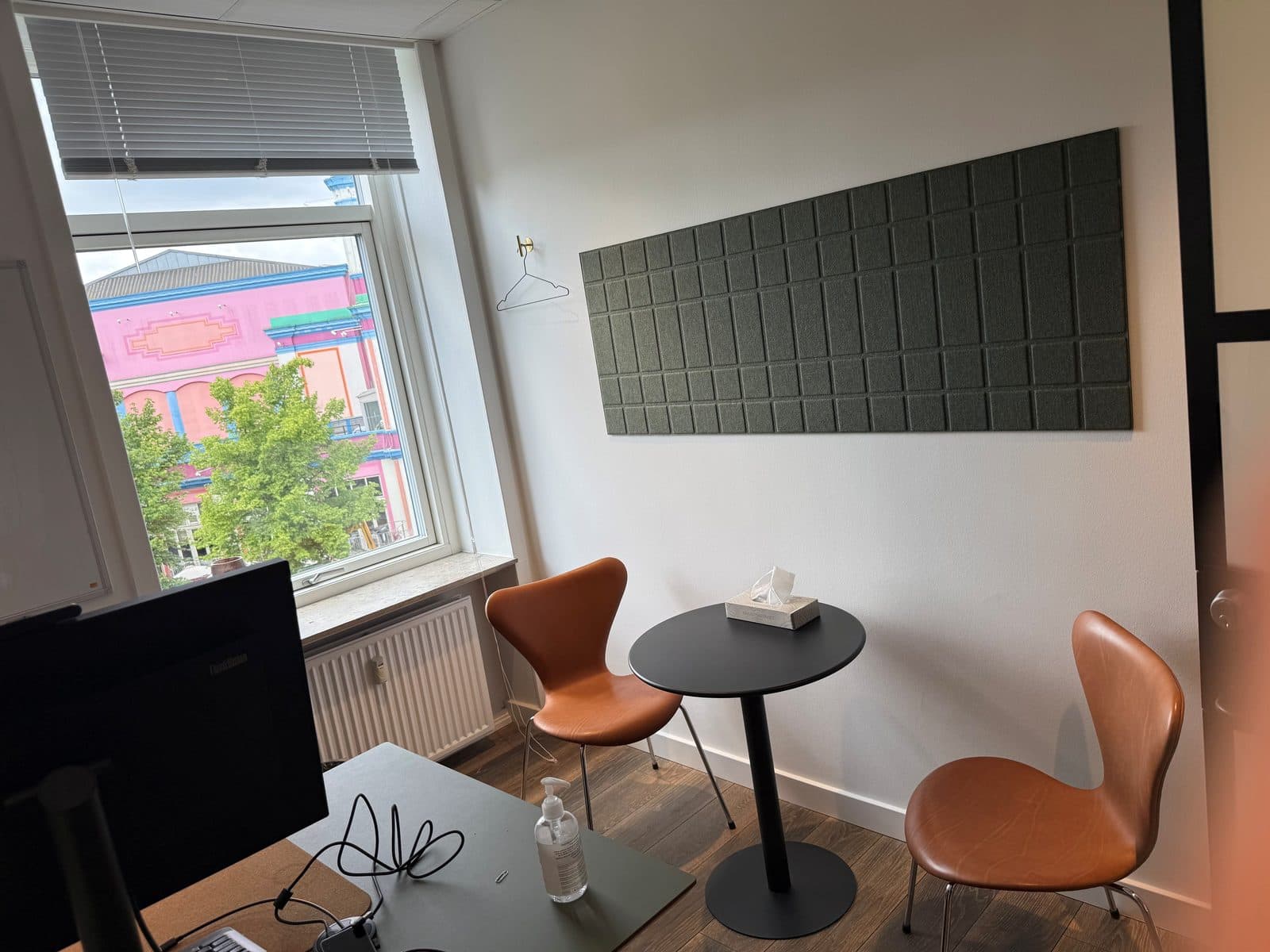 Lyst konsultationsrum med samtalestole og grøn udsigt hos Privat Psykiatrisk Center København