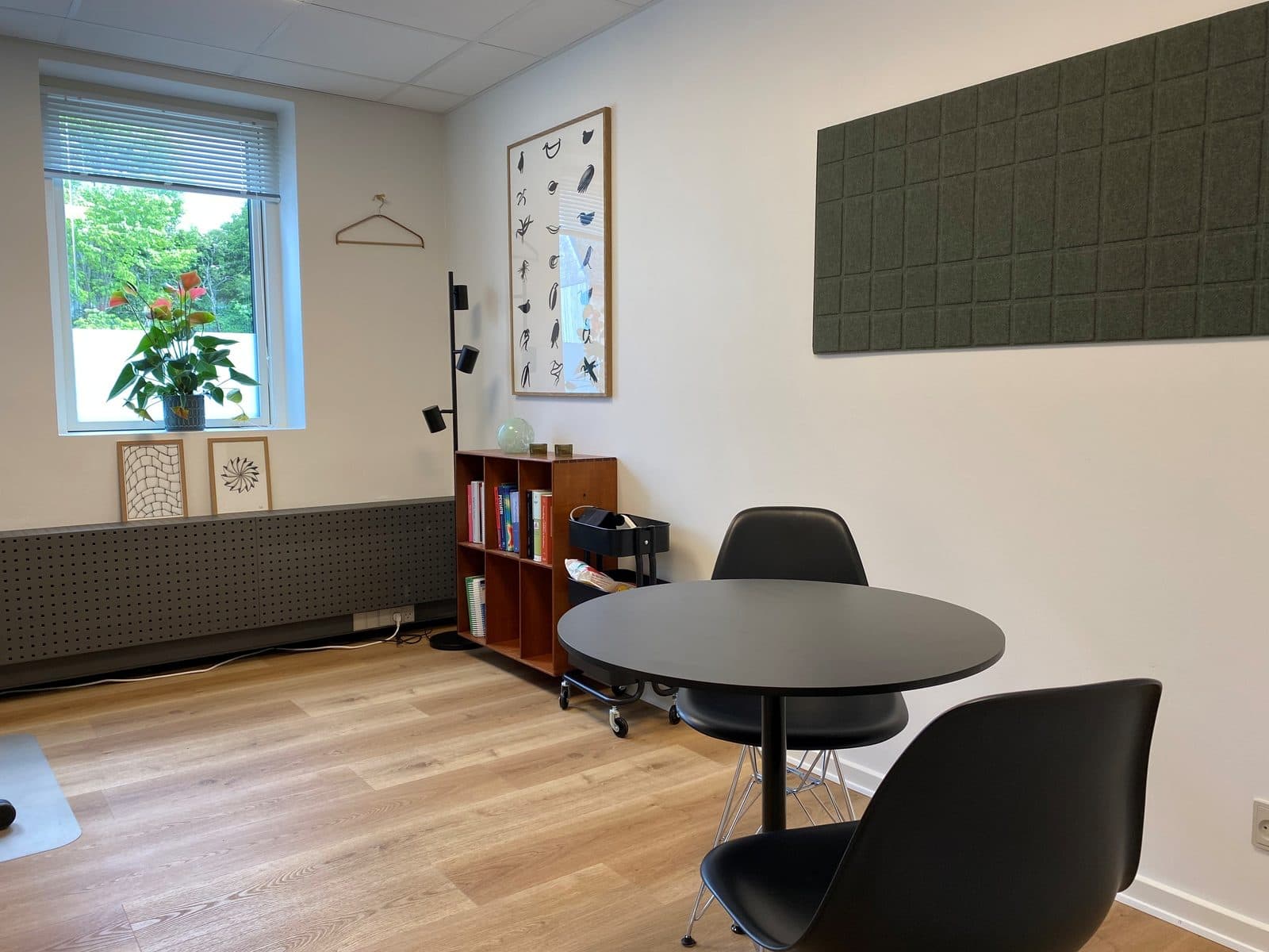 Samtalerum med rundt bord, sorte stole og nordisk kunst hos Privat Psykiatrisk Center Kolding