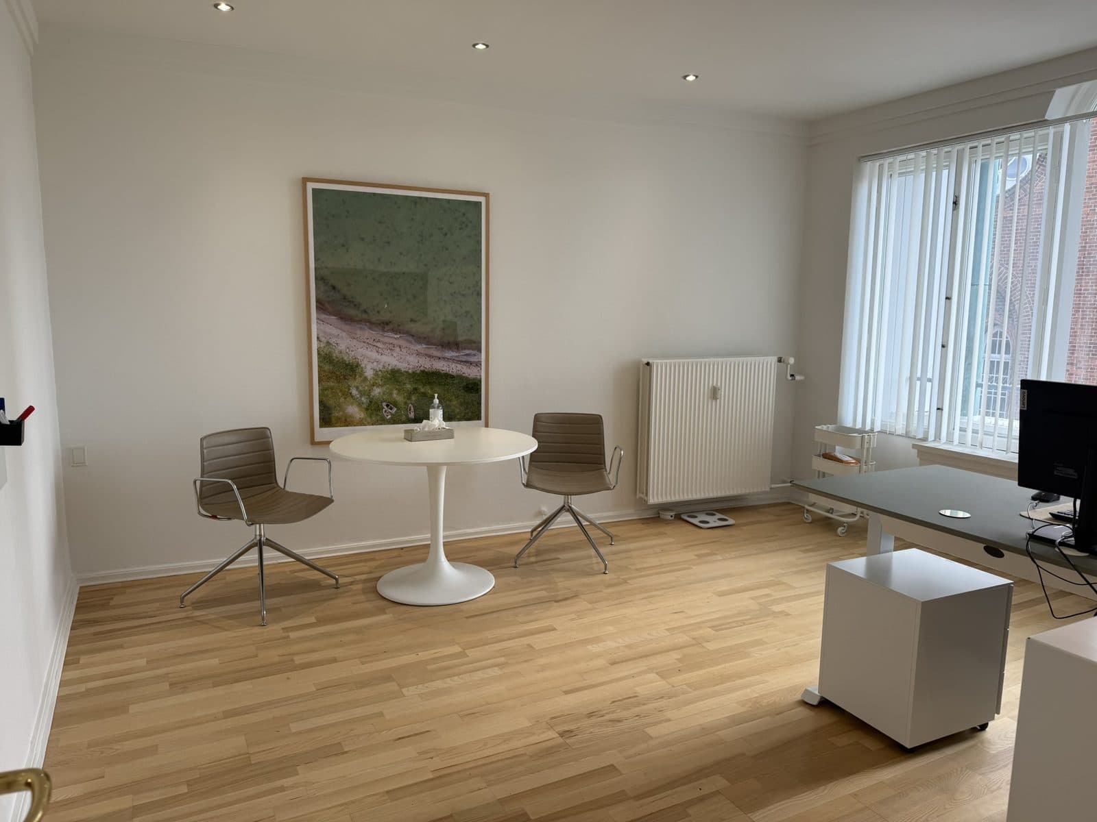 Lyst konsultationsrum med samtalebord og parketgulv hos Privat Psykiatrisk Center Odense