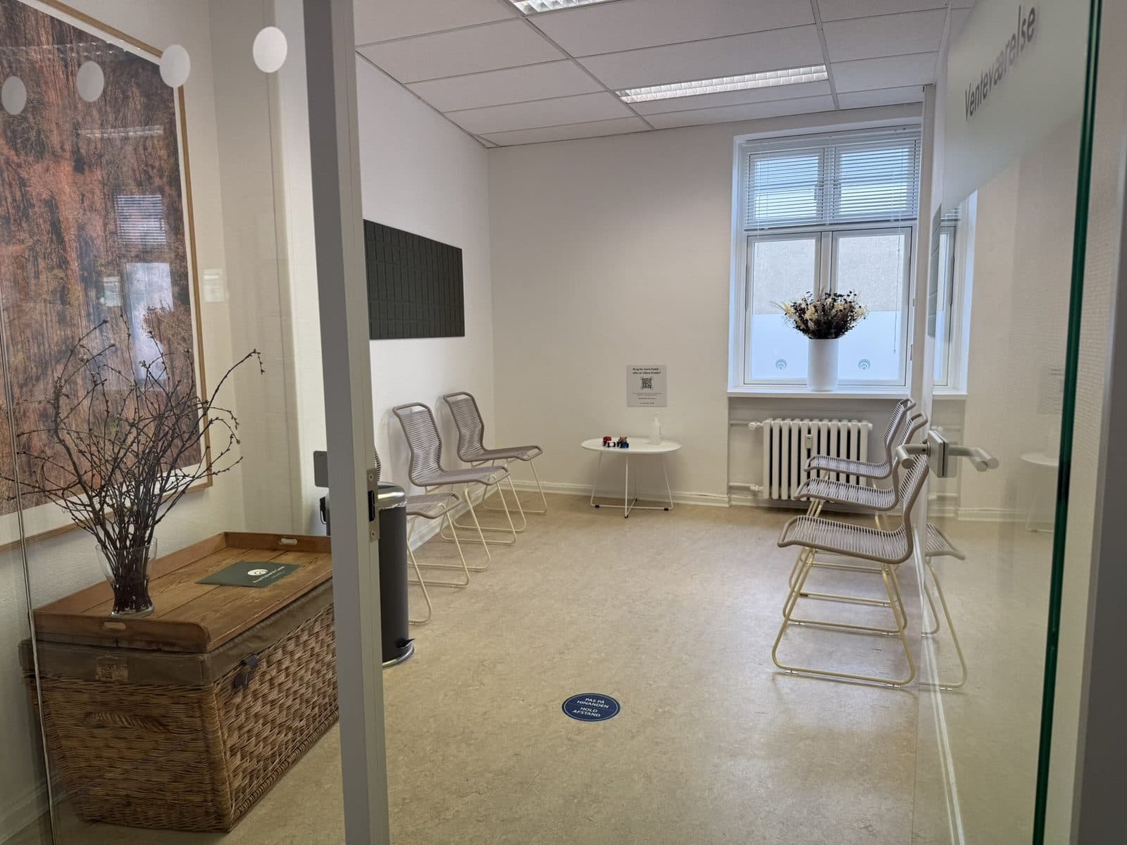 Lyst og roligt venteværelse med designerstole og blomsterdekoration hos Privat Psykiatrisk Center Odense