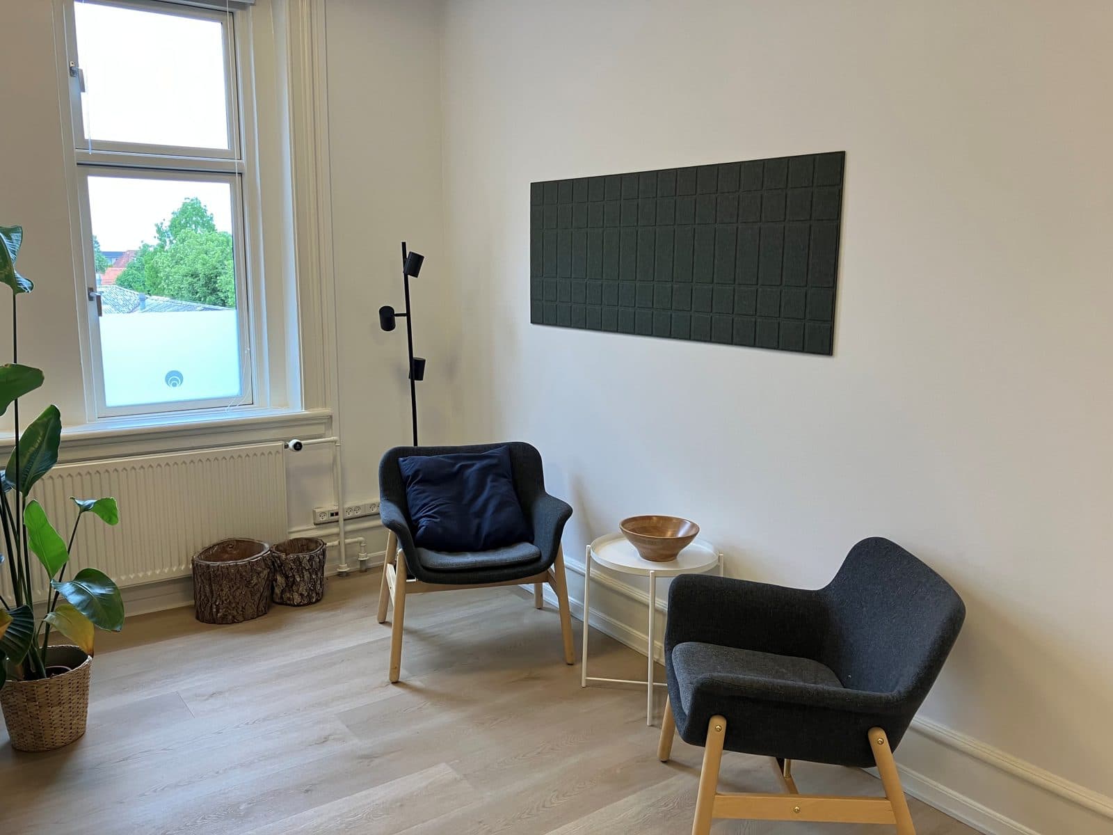 Lyst og roligt samtalerum med to lænestole og udsigt til grønne træer hos Privat Psykiatrisk Center Ringsted